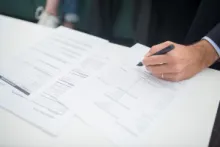 Eine Person unterschreibt Unterlagen